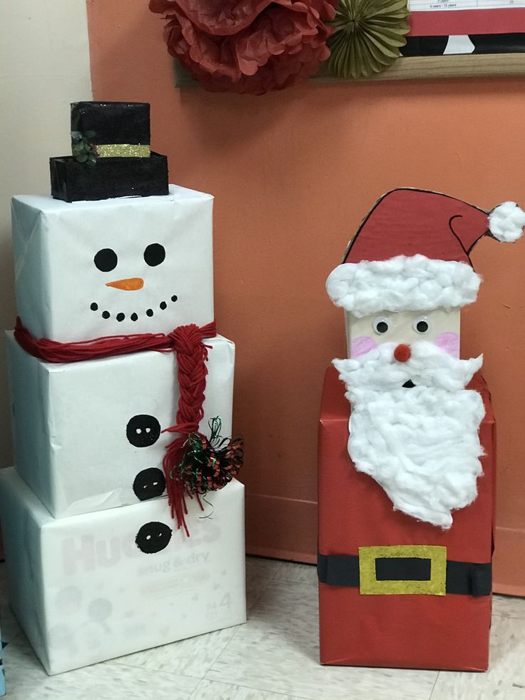 two snowmen and a santa clause made out of boxes