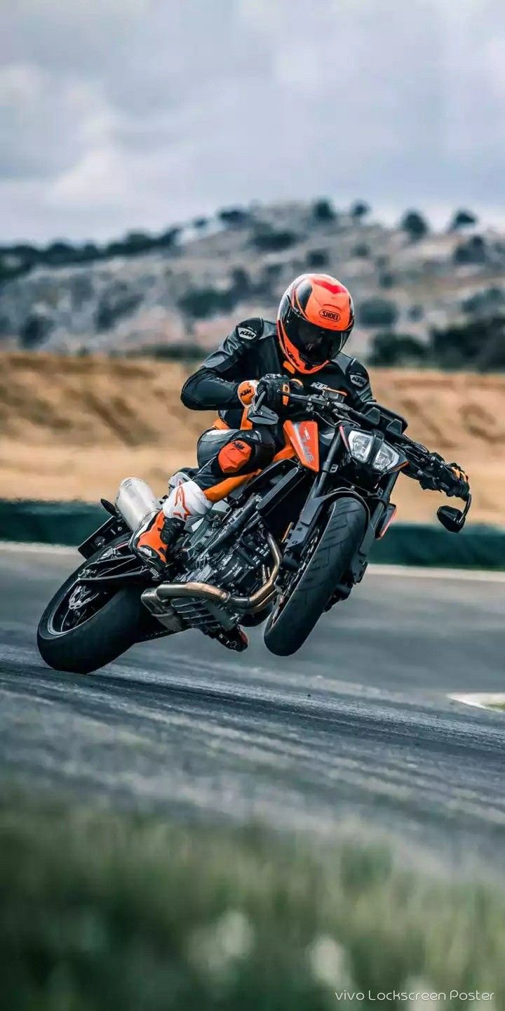 a man riding on the back of an orange motorcycle