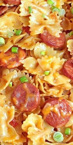 closeup of pasta with pepperoni and green onions on it in a dish that is ready to be eaten