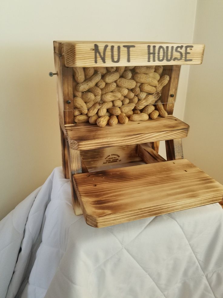 a wooden box filled with peanuts sitting on top of a bed