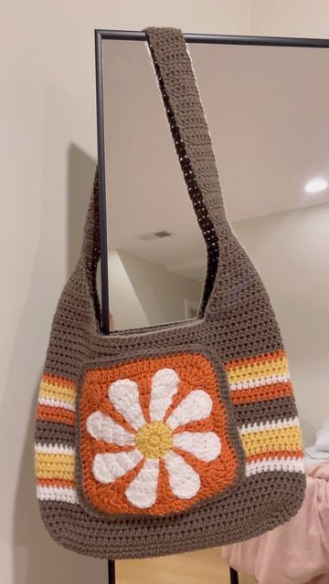 a crocheted purse hanging from a mirror