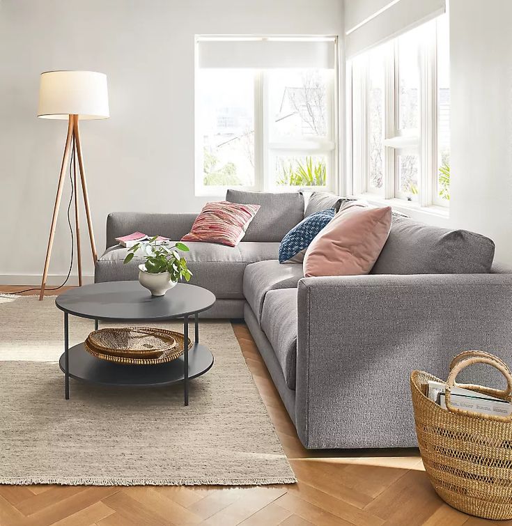 a living room filled with lots of furniture and pillows on top of a wooden floor