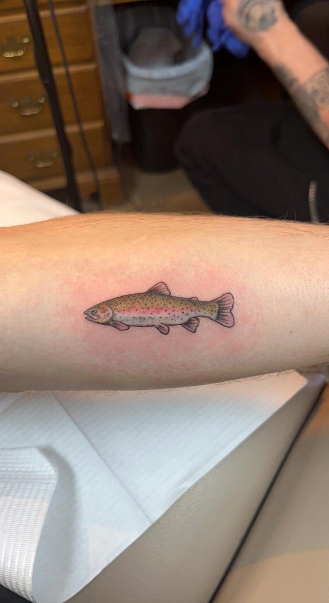 a small fish tattoo on the arm