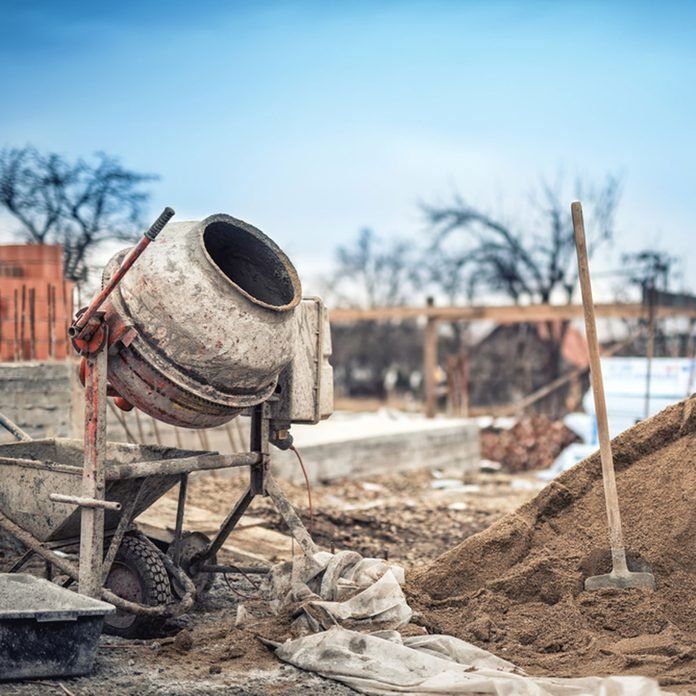 a cement mixer sitting on top of a pile of dirt