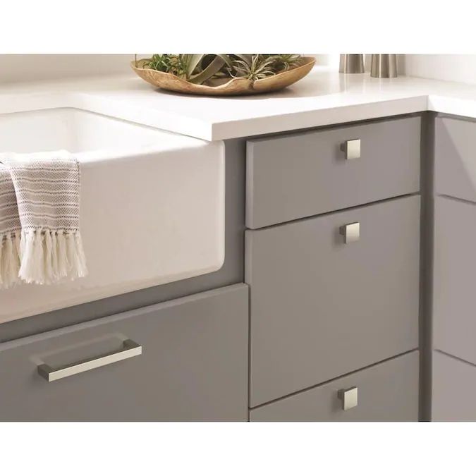 a kitchen sink with gold handles and drawers