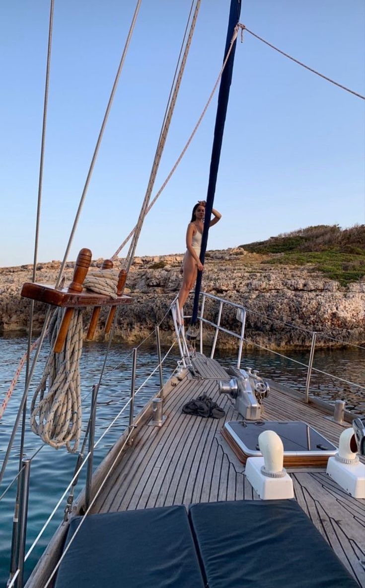 a woman standing on the deck of a sailboat