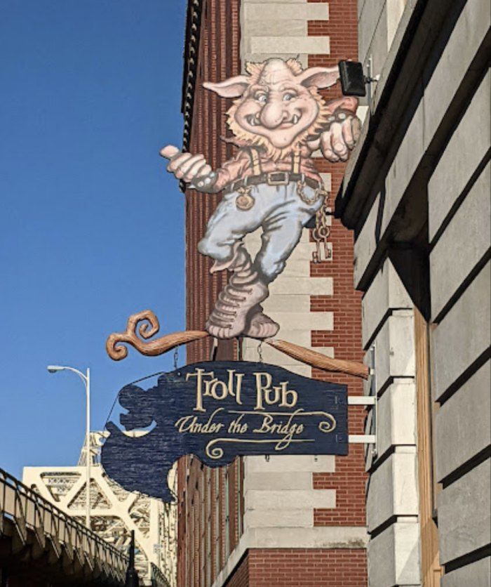 a large sign on the side of a building that says troll pot under the bridge