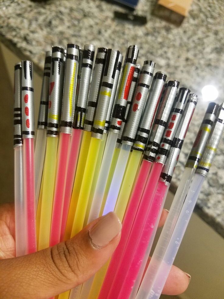 a person holding several different colored pens in their hand