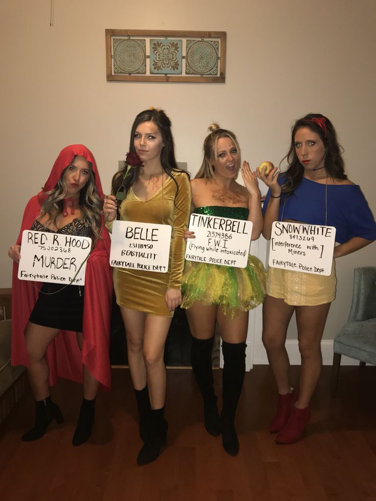 three women in costumes holding signs and posing for the camera