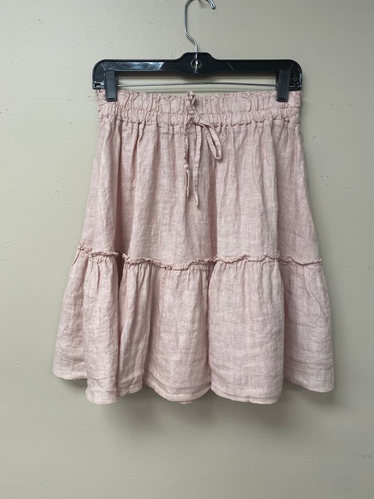 This exquisite Linen Over the Knee ruffle skirt is a luxurious piece crafted with an eye for detail and superior quality materials. Made in Italy with 100% linen and an elastic waistband featuring front drawstrings, the skirt features a romantic ruffle cascading around the hem. Perfect for any special occasion. Spring Tiered Skirt With Gathered Waist, Spring Linen Bottoms With Ruffle Hem, Vacation Tiered Skirt With Gathered Waist, Chic Ruffled Linen Bottoms, Chic Tiered Skirt With Drawstring, Vacation Linen Skirt With Elastic Waistband, Chic Linen Bottoms With Ruffles, Bohemian Linen Skirt For Spring, Spring Bohemian Linen Skirt