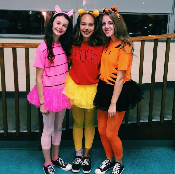 three girls dressed up in costumes posing for the camera