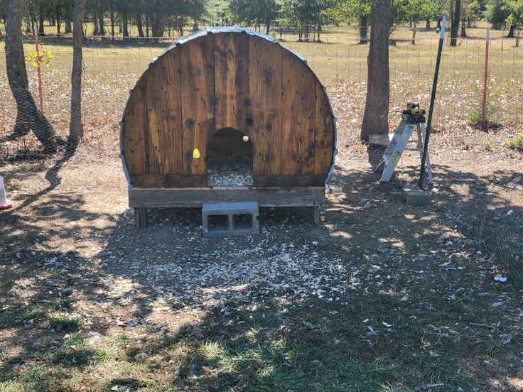 an outhouse in the middle of a field surrounded by trees and other things to do