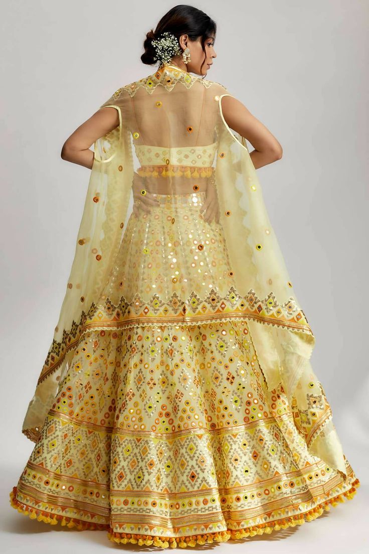 To further enhance its beauty, the ashi lehenga is adorned with pompoms and tassels. These playful elements add a whimsical touch and create a sense of movement as you glide across the dance floor. The pompoms and tassels are meticulously crafted and delicately attached, ensuring they stay in place throughout your glamorous wedding ceremony. White Traditional Sets With Tassels, Traditional White Sets With Tassels, White Sets With Tassels For Festivals, Festive Sharara With Tassels And Traditional Drape, Festive Traditional Drape Sharara With Tassels, Navratri Anarkali Dress With Tassels, Anarkali Dress With Tassels For Navratri, Traditional Saree Sets With Tassels, Festive Sharara With Tassels For Reception