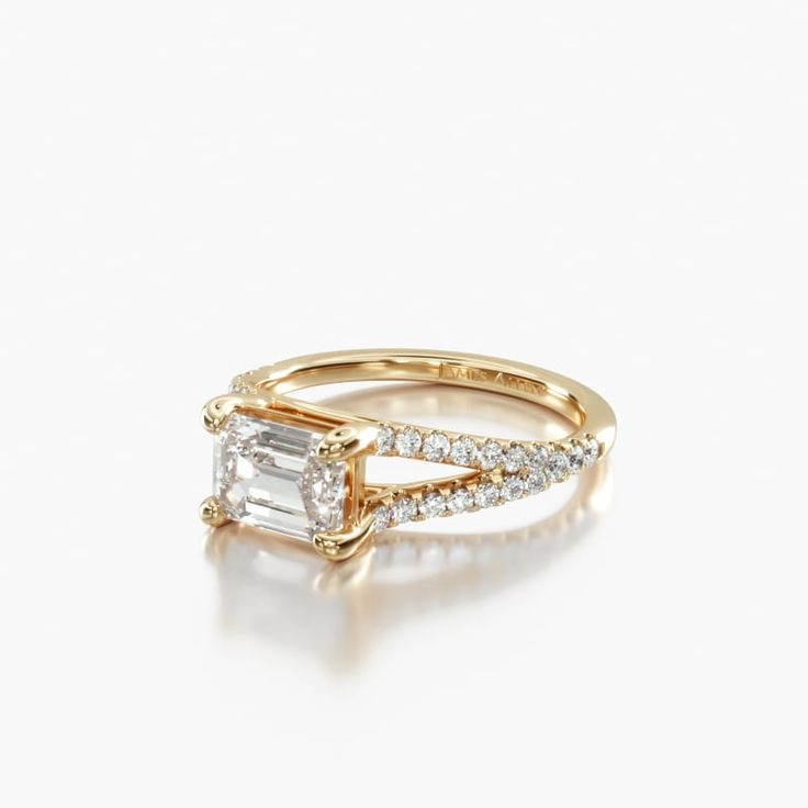 a gold engagement ring with a baguette cut diamond in the center and side stones