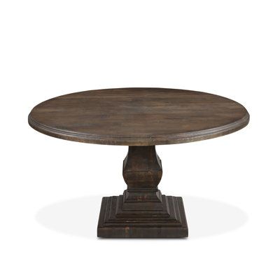 an oval wooden table with pedestals on one end and two legs, against a white background