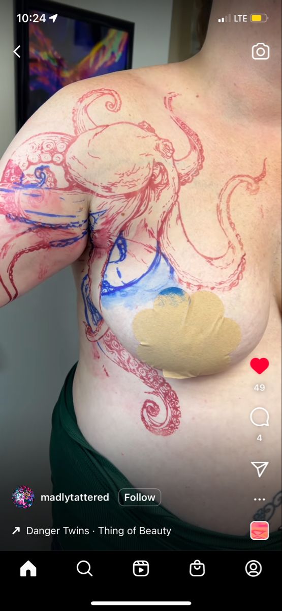 a woman's breast has been painted with red and blue ink, while she is wearing