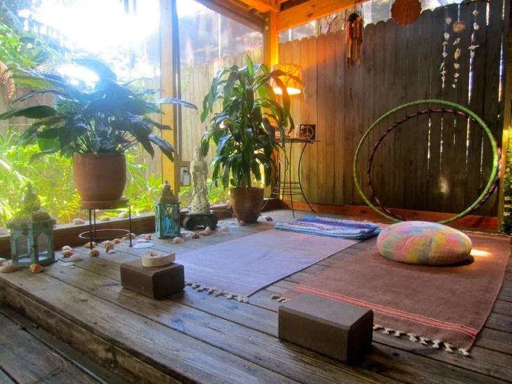 a wooden deck with yoga mats and potted plants