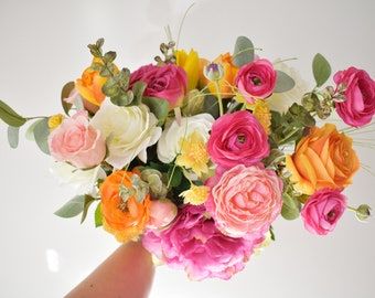 a person holding a bouquet of flowers in their hand