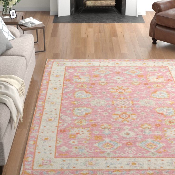 a living room filled with furniture and a rug on top of a hard wood floor