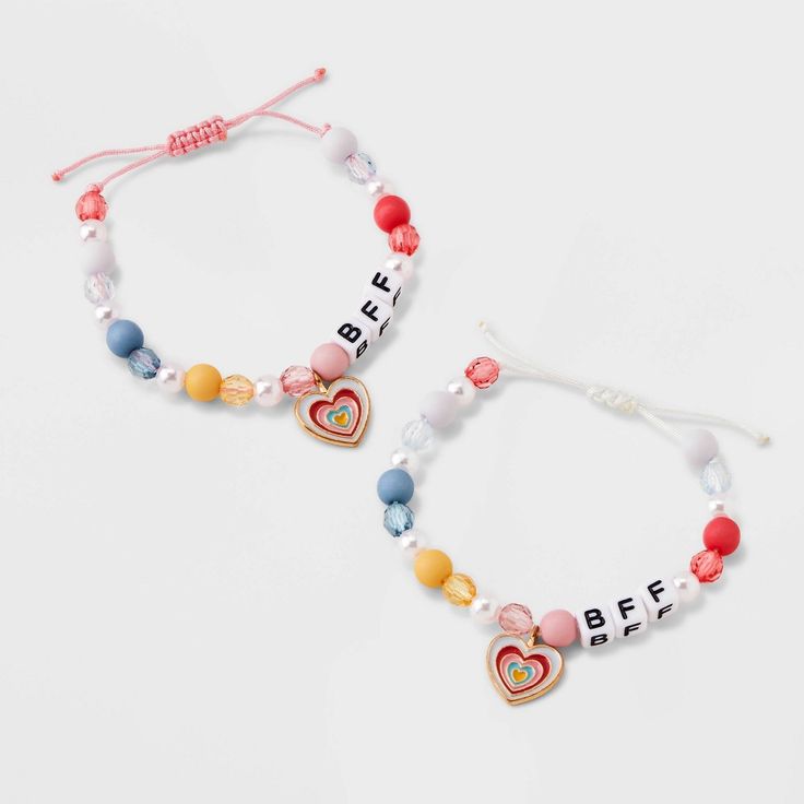 two bracelets with beads and letters on them, one has a heart shaped beaded charm