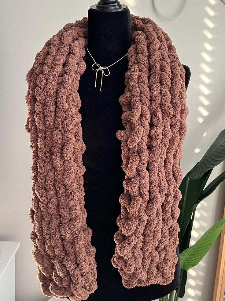 a mannequin wearing a pink knitted scarf