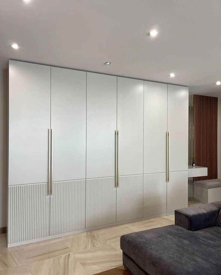 a living room filled with furniture and white cabinets