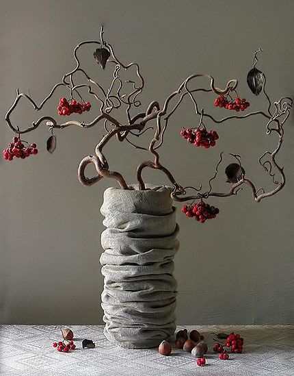 a vase filled with rocks and flowers on top of a table