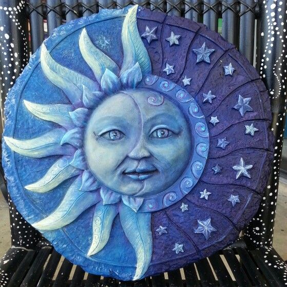 a decorative sun and moon sitting on top of a bench