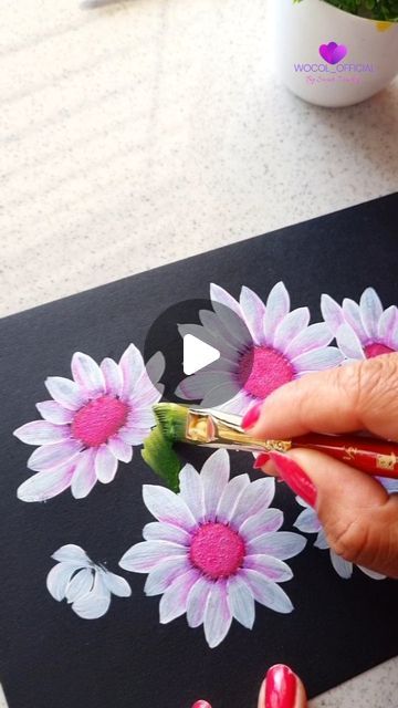 a woman is painting flowers with acrylic paint