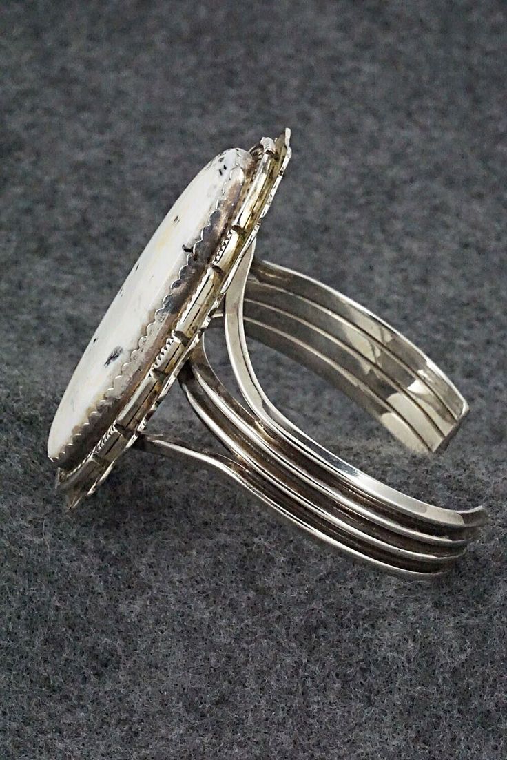 This vintage and stunning White Buffalo and sterling silver bracelet was made by a Navajo silversmith. The inside is signed L and stamped sterling.Size: 5 1/2" (will fit up to a 7" wrist)Gap: 1 1/2"Length: 2 3/8"Width: 1 1/4"Free shipping on all orders! We ship with USPS and always include tracking. All orders ship within a day of payment.Returns are accepted up to 30 days after you receive your order. Just send us a message. Our shop offers cash back or store credit. The item must be returned i Southwestern Silver Cuff Bracelet, Southwestern Style Silver Round Cuff Bracelet, Silver Artisan Bracelet, Southwestern Sterling Silver Round Cuff Bracelet, Sterling Silver Southwestern Round Cuff Bracelet, Southwestern Style Polished Bangle, Southwestern Untreated Bracelet Jewelry, Untreated Sterling Silver Bracelet, Southwestern Style Natural Bracelet