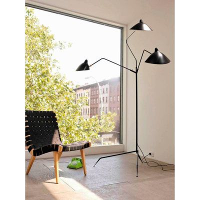 the floor lamp is next to an open window