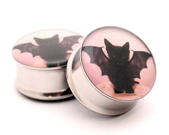 two round tins with bat images on the top one is white and has pink background