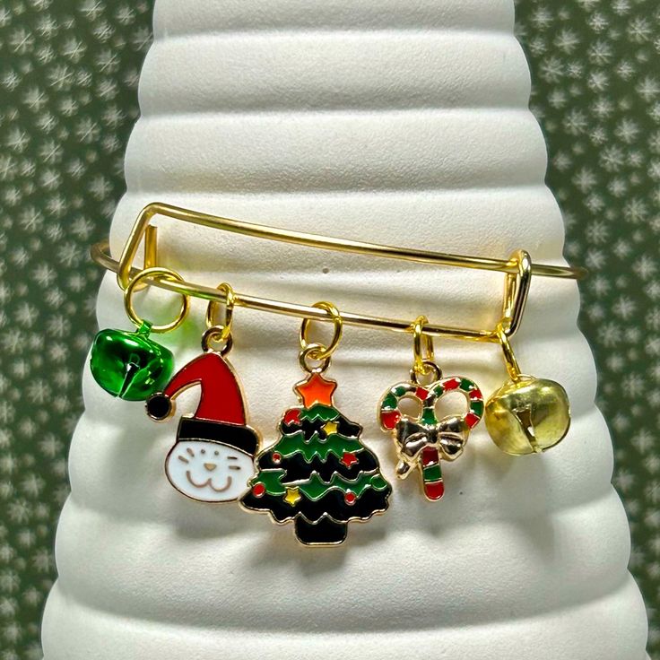 Handmade Christmas Bangle Charm Bracelet! This Stunning Gold-Tone Expandable Charm Bracelet Features Two Jingle Bells! One Green And One Gold! There Are Also Three Enamel Charms That Are Tarnish-Resistant And Hypoallergenic! The Bangle Bracelet Is Metal With A Gold-Tone And The Diameter Measures Approximately 2.6” And Is Expandable To Fit Most Wrist Sizes. It’s Perfect For Spreading Cheer During The Holiday Season! It Is Also A Great Gift Idea, Especially For Secret Santa Parties! Enjoy! Ps 25% Gold Christmas Festive Bracelets, Christmas Holiday Bracelet Jewelry, Christmas Party Adjustable Charm Bracelet, Christmas Holiday Jewelry Bracelet, Gold Adjustable Charm Bracelet For Christmas, Adjustable Christmas Jewelry For Holiday, Gold Christmas Party Bracelets, Adjustable Bracelets For Christmas Holiday, Holiday Gift Charm Bracelet Adjustable