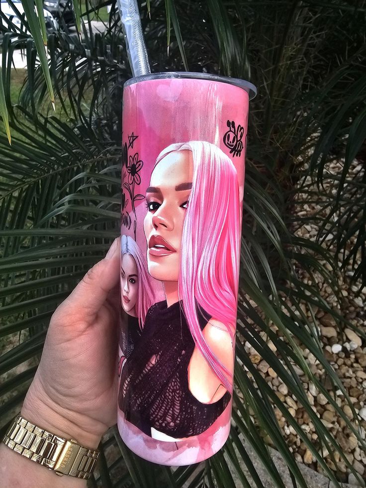 a woman with pink hair is holding up a pink cup that has an image of herself on it