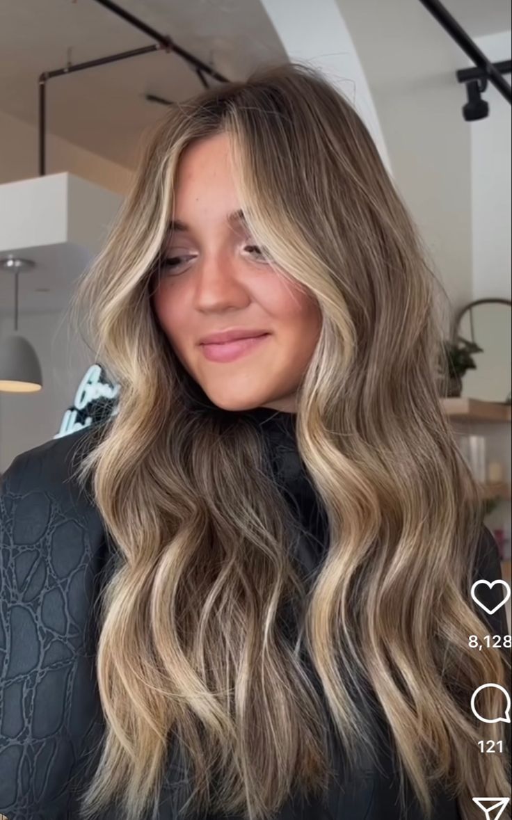 a woman with long blonde hair is smiling at the camera