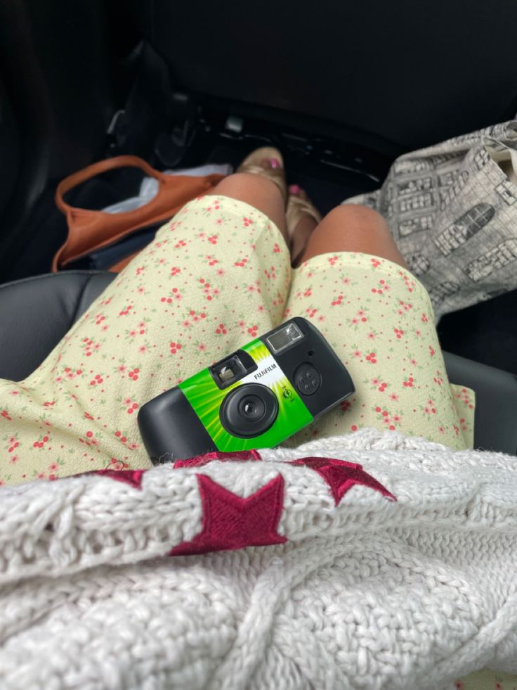 a woman laying in her car seat holding a camera