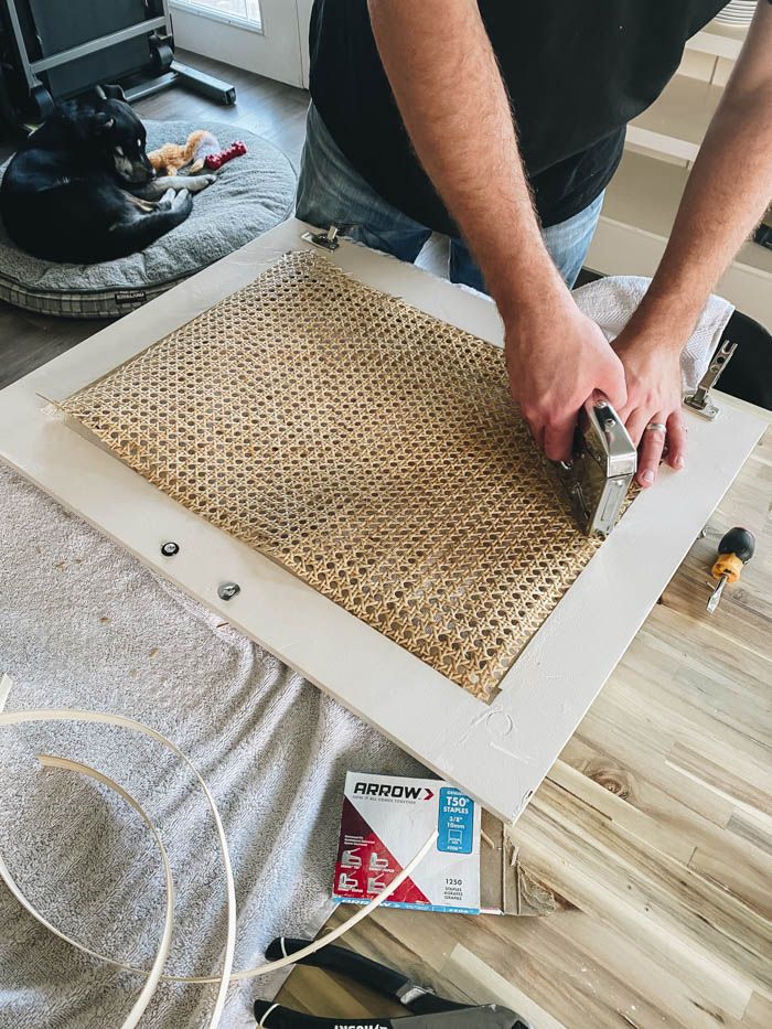 a man is working on a piece of wood that has been made into a floor mat