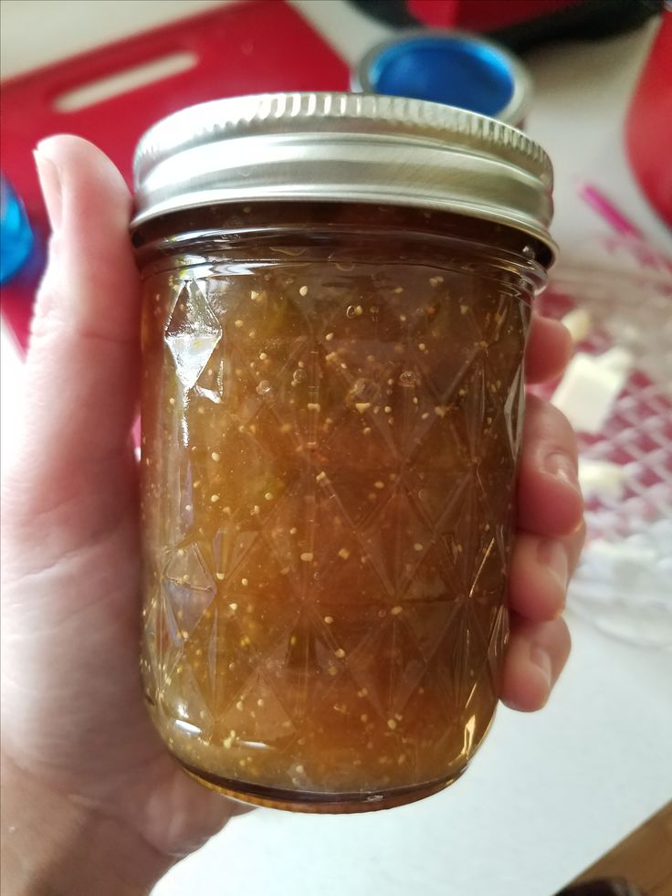 a person holding a jar filled with food