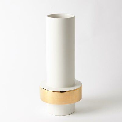 a white vase sitting on top of a wooden stand