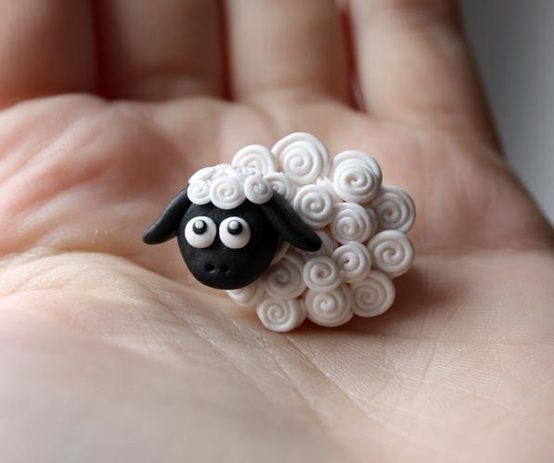 a small toy sheep sitting on top of someone's hand