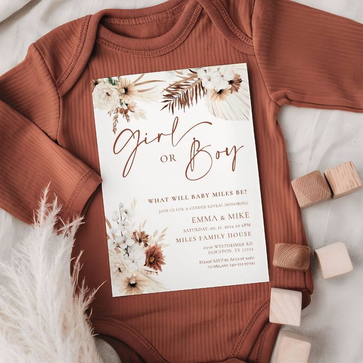 a baby announcement card on top of a bodysuit with flowers and leaves in it