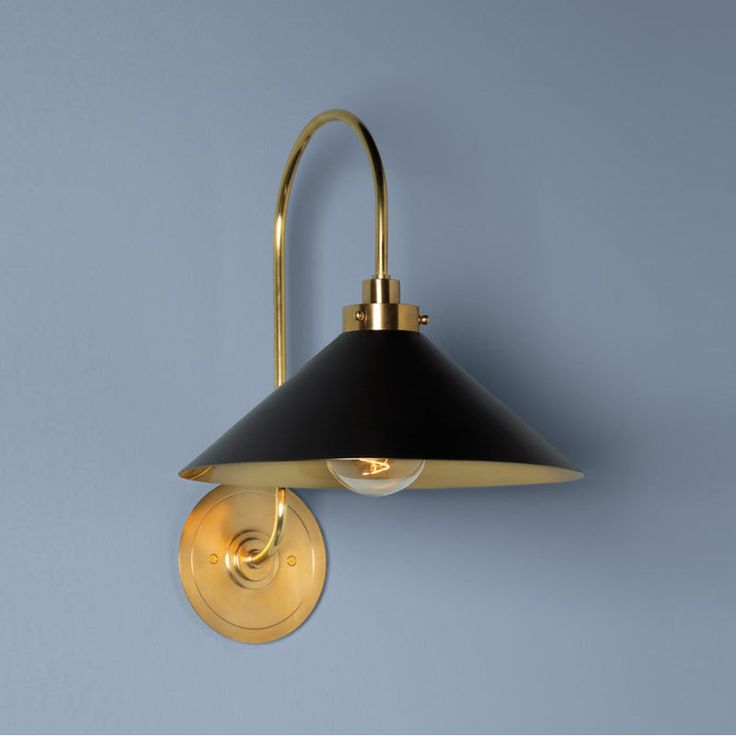 a black and gold wall light against a blue background