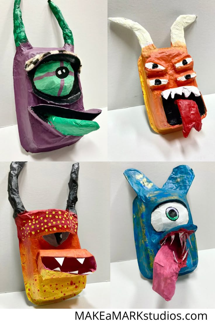 four different paper mache masks with mouths and eyes on them, all decorated in various colors