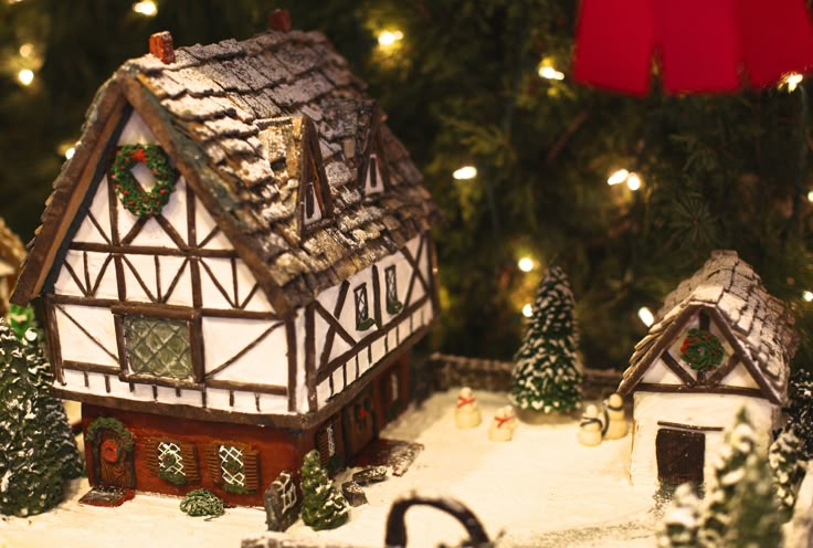 a close up of a christmas scene with a house and trees in the foreground