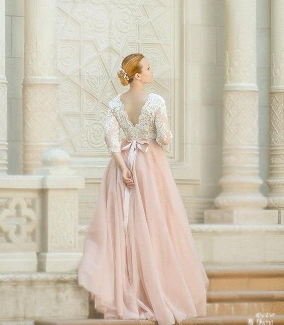 a woman in a pink dress is standing on the steps with her back to the camera