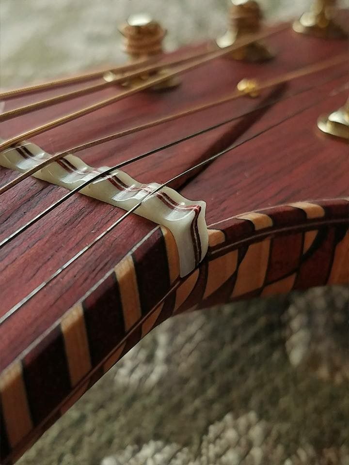 a close up view of the strings on an acoustic guitar's neck and frets