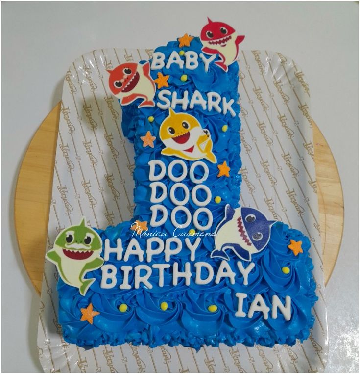 a baby shark birthday cake with blue frosting and decorations on it's top