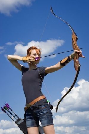 a woman holding a bow and arrow in her hands