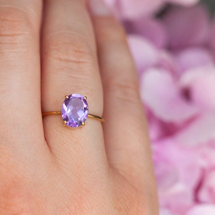 How can something so simple as an oval Amethyst solitaire ring, be so beautiful, you ask? The answer is in the gemstone itself. With a gorgeous vivid purple color, this ring just pops out on your finger and dazzles everyone. To turn it up a notch, add complimentary stacking rings, to create a one-of-a-kind ring set - s Purple Oval Birthstone Ring, Oval Lavender Amethyst Ring For Gift, Lavender Oval Amethyst Ring For Gift, Lavender Amethyst Ring With Oval Shape, Purple Amethyst Solitaire Ring In Oval Shape, Oval Purple Amethyst Ring For Gift, Oval Purple Solitaire Birthstone Ring, Oval Solitaire Amethyst Ring Gift, Oval Solitaire Amethyst Ring For Anniversary