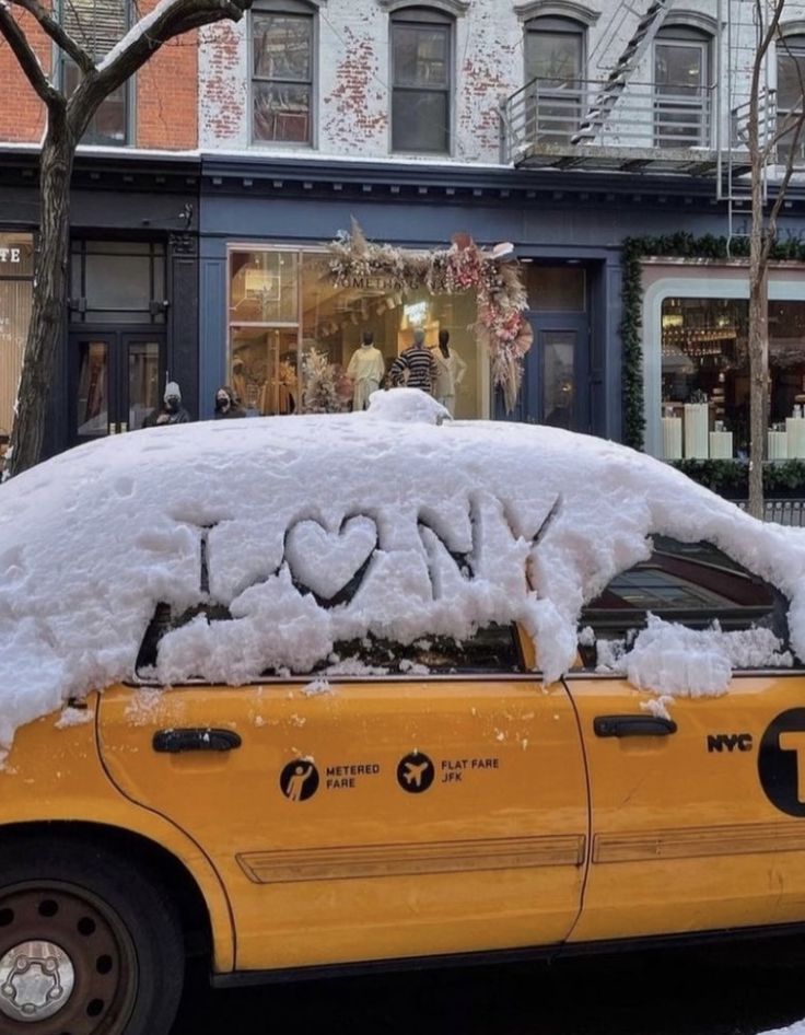 a taxi cab covered in snow with the word love written on it's windshield